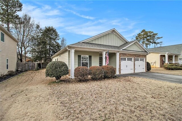 view of front of home with fence, driveway, a garage, and board and batten siding