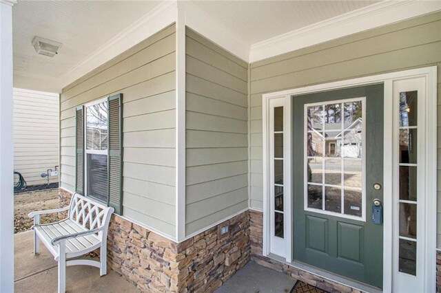entrance to property featuring stone siding and a porch