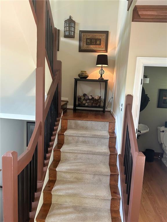 staircase featuring wood finished floors and baseboards