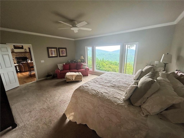 carpeted bedroom featuring crown molding, a fireplace, and a ceiling fan