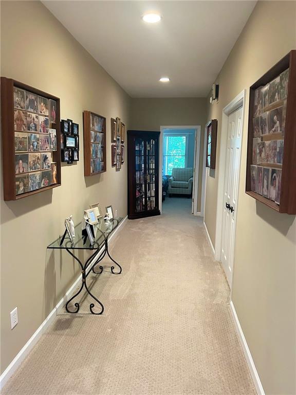 hallway featuring carpet, baseboards, and recessed lighting