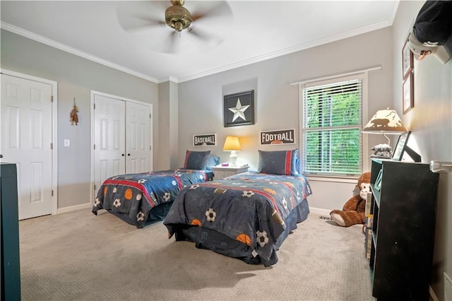 bedroom with carpet flooring, crown molding, baseboards, a ceiling fan, and a closet
