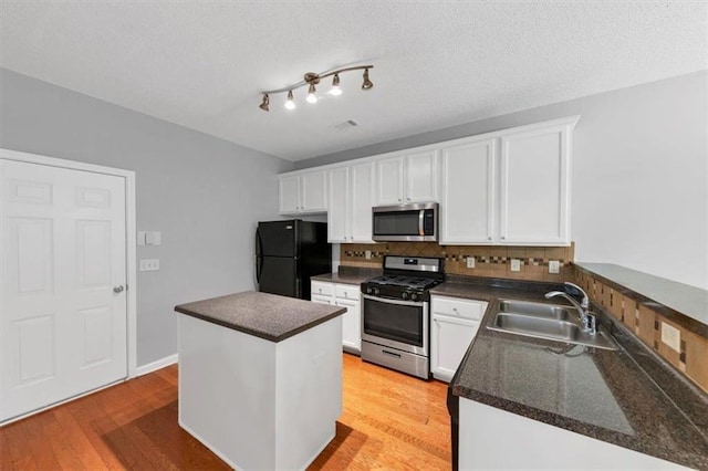 2165 Capella Cir S, Fulton, GA 30331 - kitchen featuring stainless steel appliances, dark countertops, backsplash, white cabinetry, and a textured ceiling