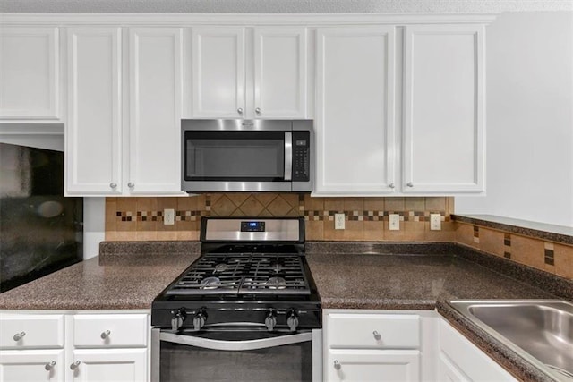 2165 Capella Cir S, Fulton, GA 30331 - kitchen with stainless steel appliances, white cabinets, dark countertops, and decorative backsplash