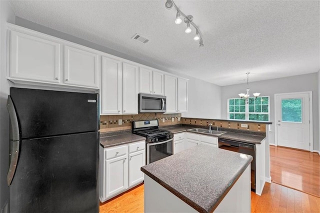 2165 Capella Cir S, Fulton, GA 30331 - kitchen featuring black appliances, a peninsula, dark countertops, white cabinets, and a textured ceiling