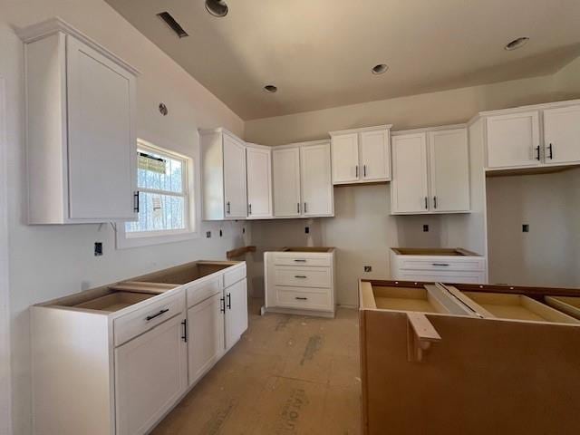 kitchen with white cabinets, visible vents, and light wood-style floors