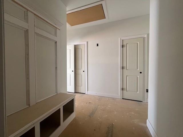 mudroom with unfinished concrete floors and baseboards