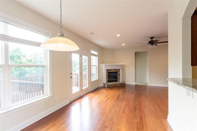 unfurnished living room featuring hardwood / wood-style flooring, a fireplace, and ceiling fan