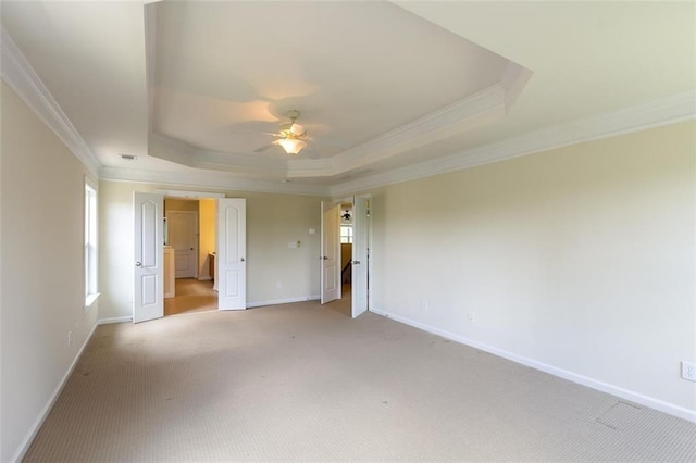 carpeted spare room featuring crown molding, ceiling fan, and a tray ceiling