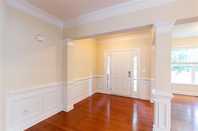 foyer with crown molding, wood-type flooring, and decorative columns