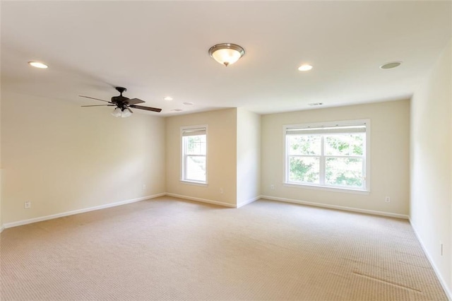 empty room featuring ceiling fan and light carpet