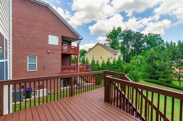 wooden deck featuring a lawn