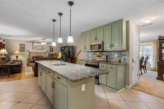 kitchen featuring appliances with stainless steel finishes, light tile patterned flooring, visible vents, and green cabinetry