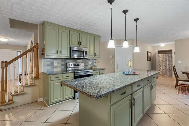 kitchen featuring light tile patterned floors, decorative backsplash, stainless steel appliances, and green cabinetry