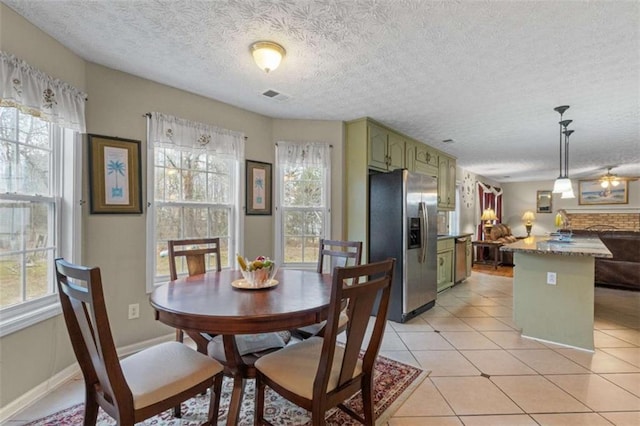 dining area with visible vents, a textured ceiling, baseboards, and light tile patterned floors