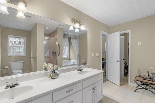 full bath with a stall shower, a sink, a textured ceiling, and toilet