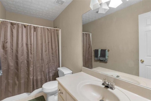 bathroom featuring a textured ceiling, curtained shower, toilet, vanity, and visible vents