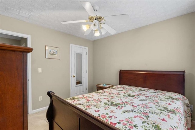 bedroom with a ceiling fan, light colored carpet, a textured ceiling, and baseboards