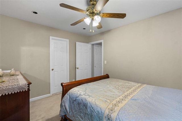 bedroom with ceiling fan, baseboards, and light colored carpet