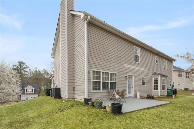 back of property featuring a patio area, a chimney, central AC, and a yard