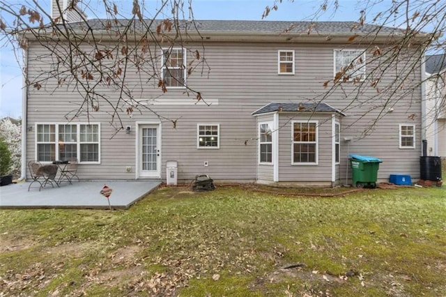 back of property with a patio area, a yard, and central AC