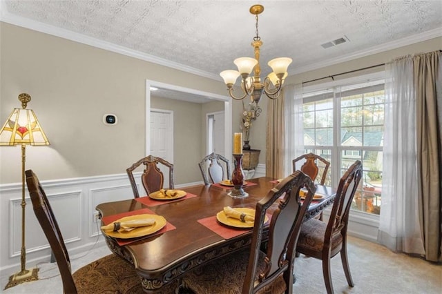 dining area featuring ornamental molding, visible vents, a textured ceiling, and an inviting chandelier