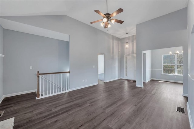 unfurnished living room featuring high vaulted ceiling, dark hardwood / wood-style flooring, and ceiling fan with notable chandelier