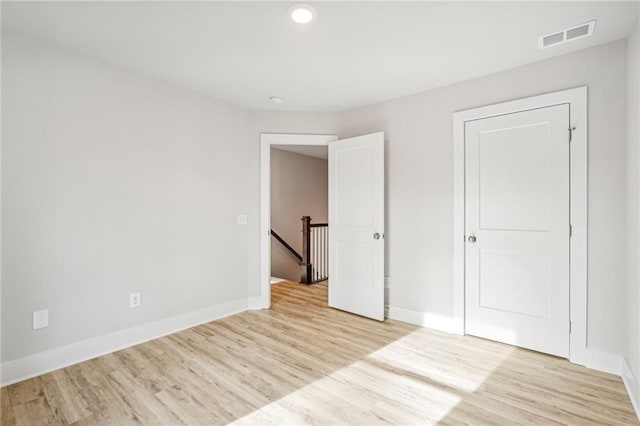 unfurnished bedroom with baseboards, visible vents, and light wood finished floors