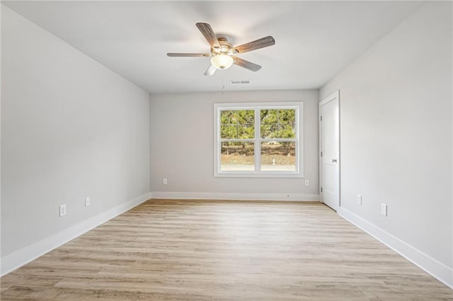 empty room with ceiling fan, light wood-type flooring, visible vents, and baseboards