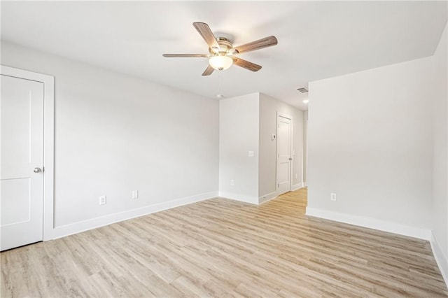 empty room with a ceiling fan, light wood-type flooring, visible vents, and baseboards