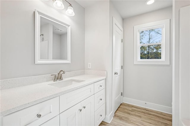 bathroom with vanity, baseboards, and wood finished floors