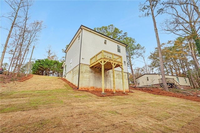 rear view of house with a yard and a wooden deck