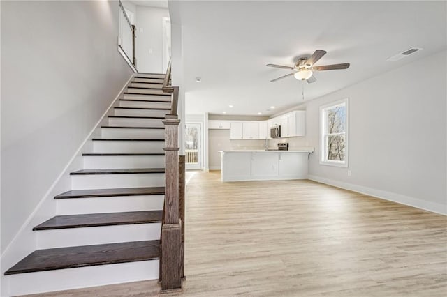 staircase with baseboards, visible vents, a ceiling fan, wood finished floors, and recessed lighting