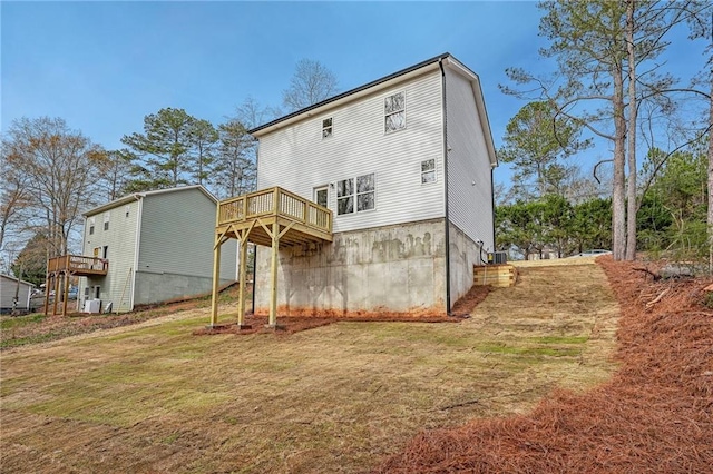 rear view of property with a deck and a lawn