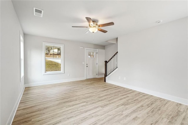 interior space with light wood-style floors, baseboards, stairs, and visible vents