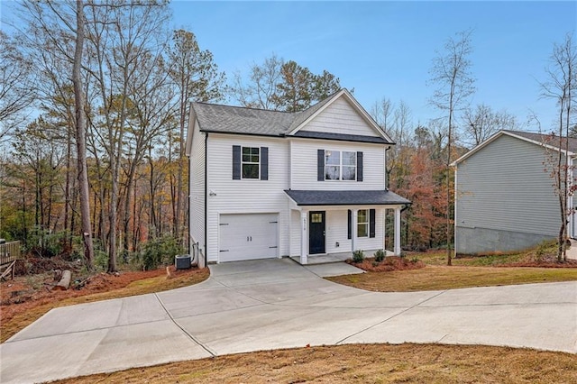 traditional-style home with driveway, an attached garage, and central air condition unit