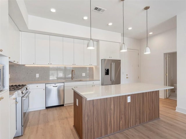 675 Drewry St NE Unit 205, Atlanta, GA 30306 - kitchen featuring appliances with stainless steel finishes, a sink, a center island, light wood finished floors, and tasteful backsplash