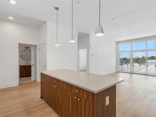 675 Drewry St NE Unit 205, Atlanta, GA 30306 - kitchen featuring light wood-type flooring, baseboards, a center island, a sink, and open floor plan