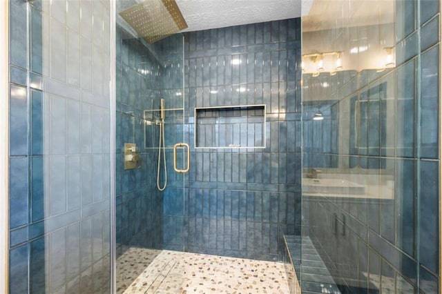 bathroom with an enclosed shower and a textured ceiling