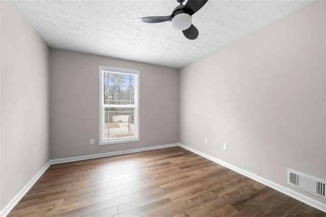 unfurnished room with ceiling fan, wood-type flooring, and a textured ceiling