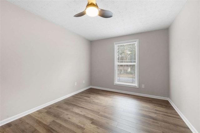 empty room featuring ceiling fan, wood-type flooring, and a textured ceiling