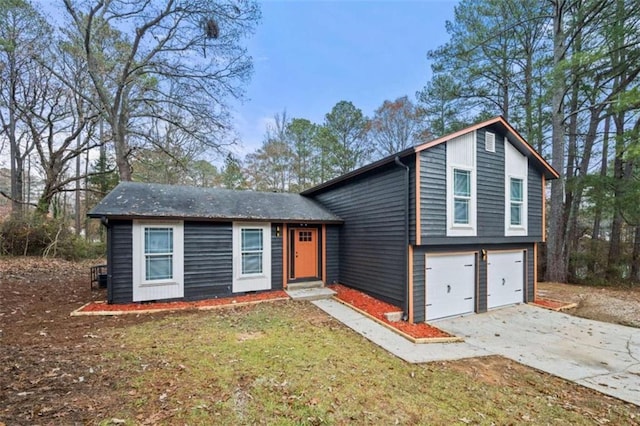 split level home with a garage and a front lawn