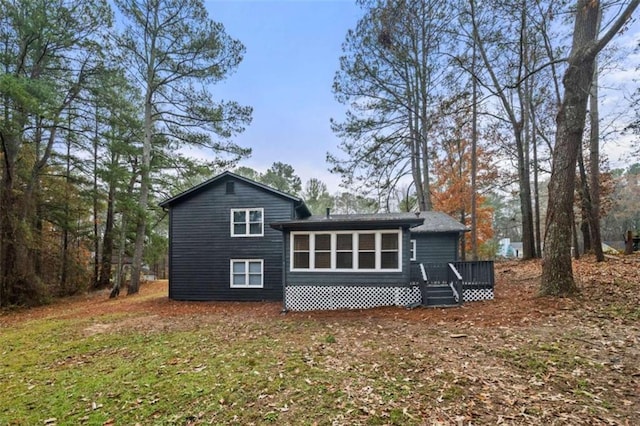 back of property featuring a lawn and a wooden deck