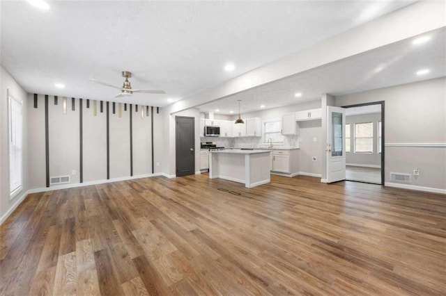 unfurnished living room featuring ceiling fan and light hardwood / wood-style flooring