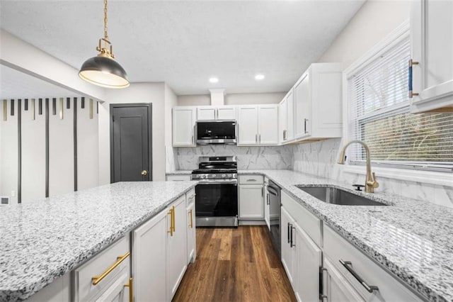 kitchen featuring white cabinets, appliances with stainless steel finishes, hanging light fixtures, and sink