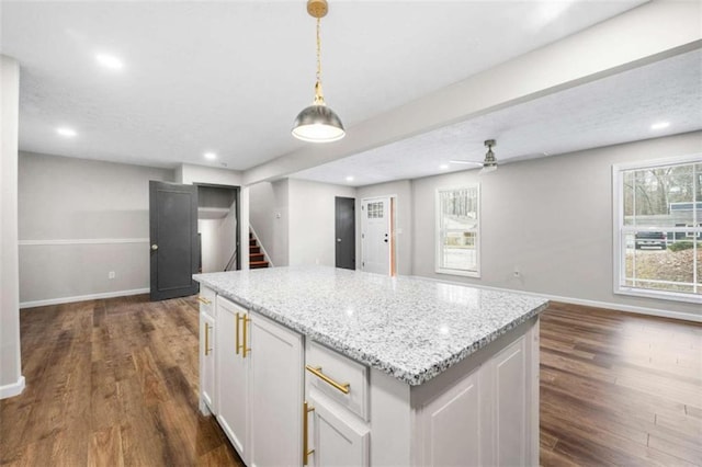 kitchen with hanging light fixtures, white cabinets, a healthy amount of sunlight, and dark hardwood / wood-style floors