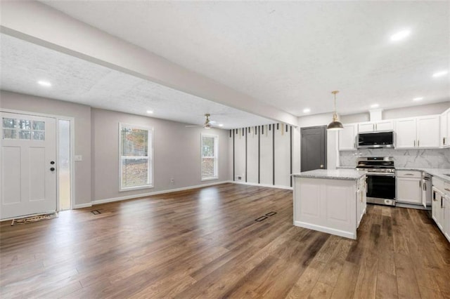 kitchen featuring white cabinets, dark hardwood / wood-style floors, decorative light fixtures, a kitchen island, and stainless steel appliances