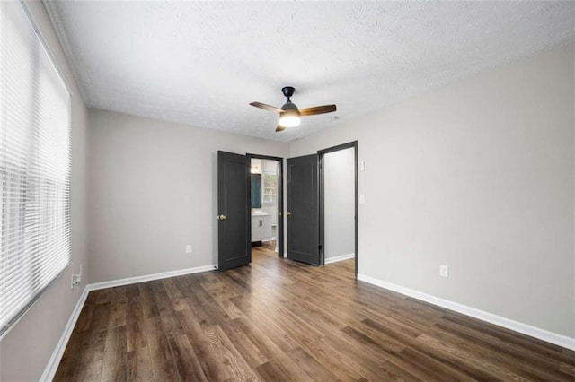 unfurnished bedroom with ceiling fan, dark wood-type flooring, and a textured ceiling