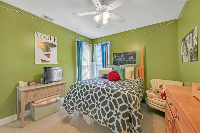 carpeted bedroom featuring a ceiling fan, visible vents, and baseboards