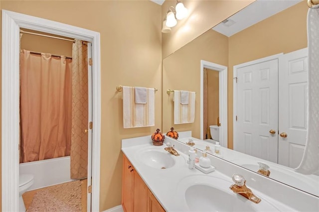 full bath with toilet, shower / bath combination with curtain, double vanity, and a sink